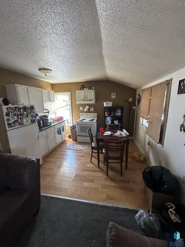 living room with lofted ceiling, a textured ceiling, and light wood-style flooring