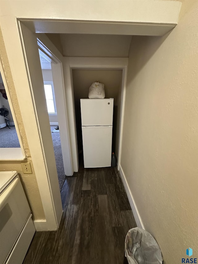 hallway with dark wood-type flooring and baseboards