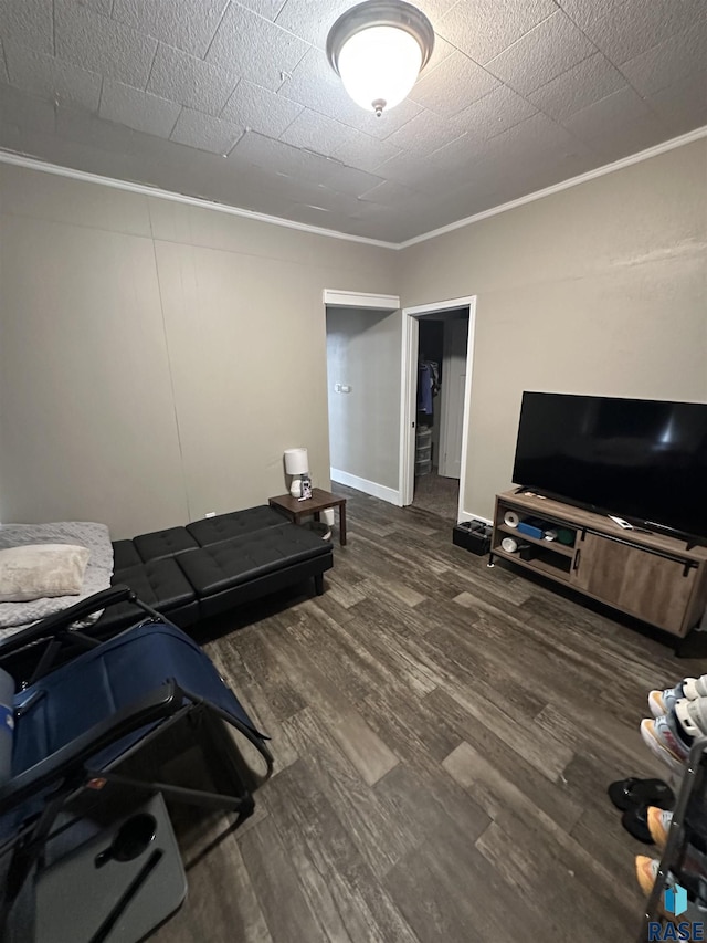 workout room featuring baseboards, wood finished floors, and crown molding