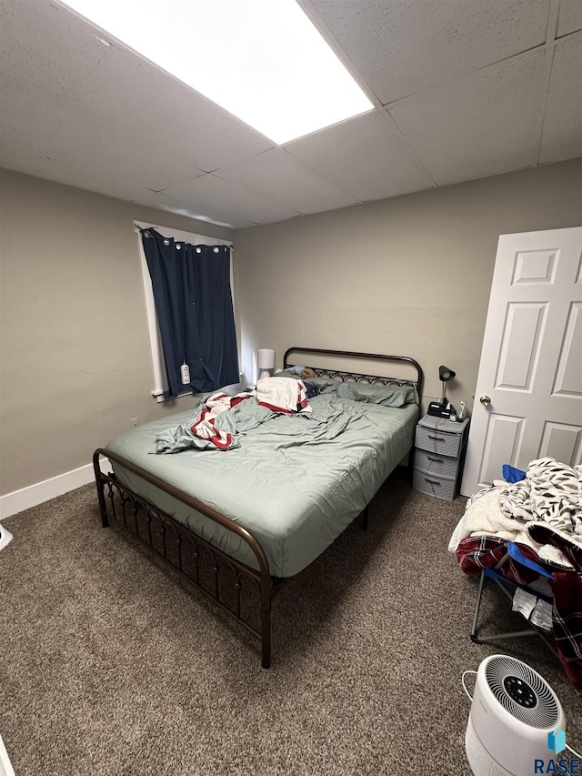 bedroom with baseboards, a paneled ceiling, and carpet