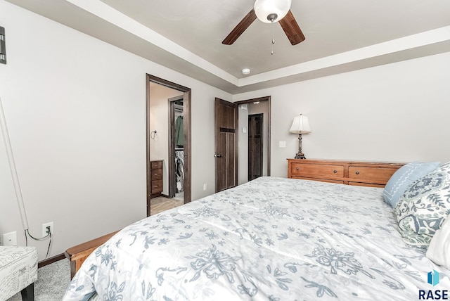 bedroom featuring a tray ceiling, carpet floors, and ceiling fan
