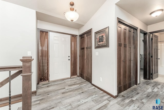 entryway with baseboards and light wood finished floors