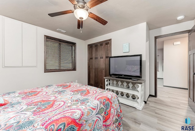 bedroom featuring baseboards, visible vents, light wood-style flooring, and ceiling fan