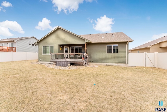 back of property featuring a yard, a fenced backyard, and a deck
