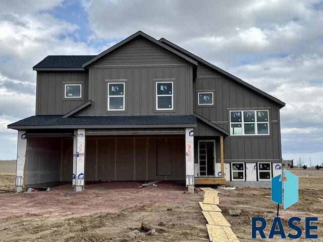 view of front of property with dirt driveway, an attached garage, and board and batten siding