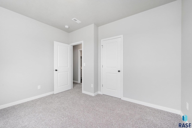 unfurnished bedroom featuring carpet floors, baseboards, and visible vents