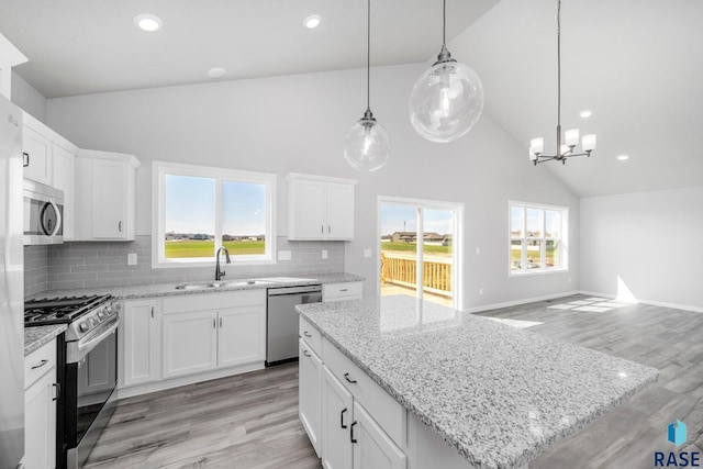 kitchen featuring light wood finished floors, a sink, appliances with stainless steel finishes, and a chandelier