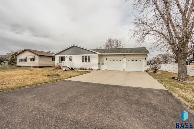 ranch-style house with a front yard, driveway, a garage, and fence