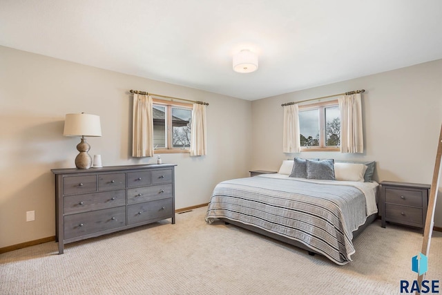 bedroom featuring light carpet and baseboards
