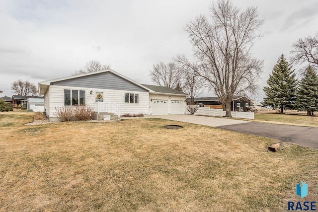ranch-style home featuring an attached garage, concrete driveway, and a front yard