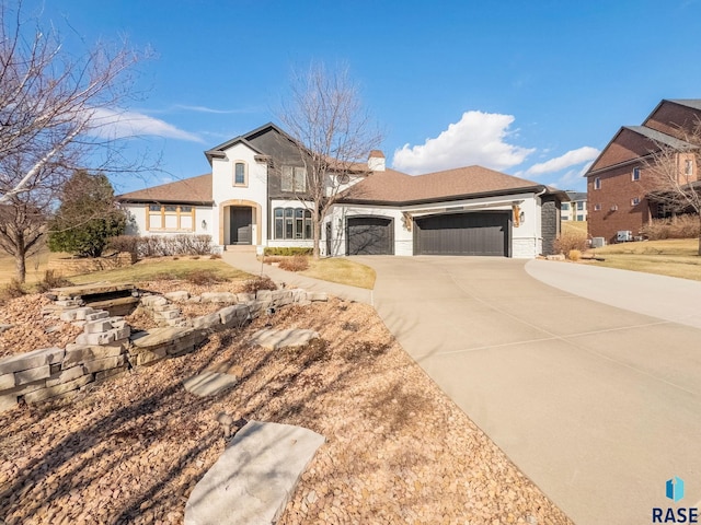 view of front of home with concrete driveway, a garage, roof with shingles, and a chimney