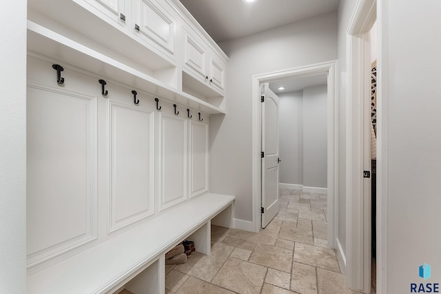mudroom with stone tile flooring, baseboards, and recessed lighting