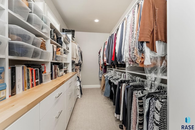 walk in closet featuring light carpet