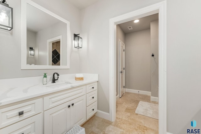 bathroom featuring vanity, baseboards, and visible vents