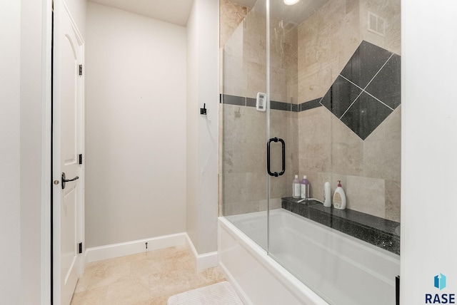 bathroom with baseboards, bath / shower combo with glass door, and visible vents