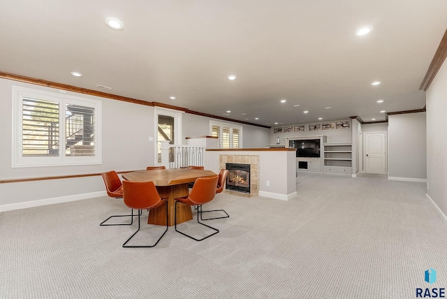 dining space with ornamental molding, a tile fireplace, and a healthy amount of sunlight