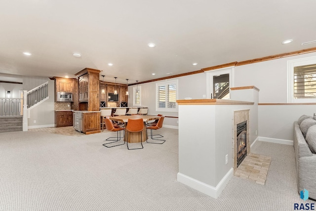 kitchen with glass insert cabinets, a breakfast bar area, stainless steel microwave, and a center island