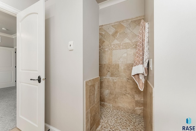 full bath with a tile shower and ornamental molding