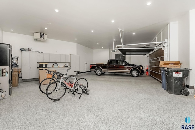 garage with freestanding refrigerator, recessed lighting, and a garage door opener