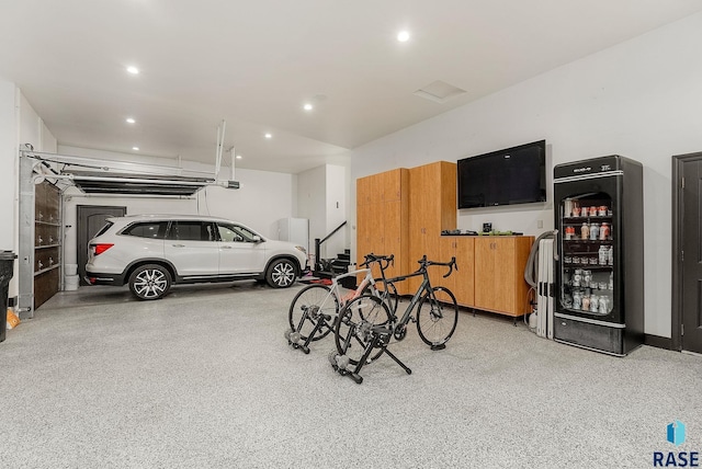 garage featuring a garage door opener, beverage cooler, and recessed lighting