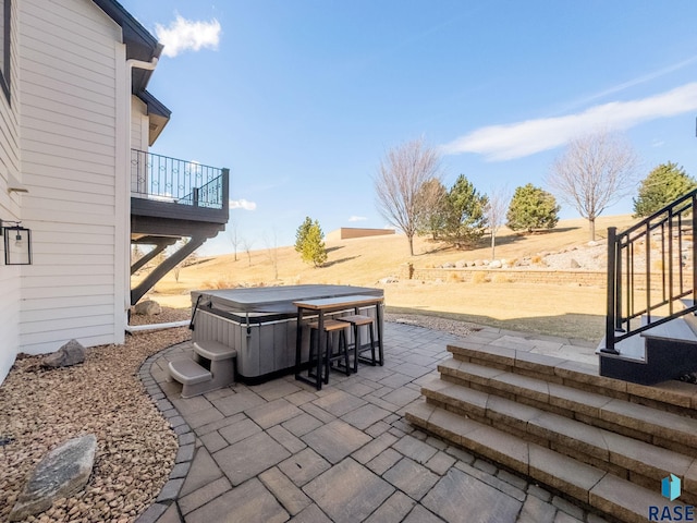 view of patio / terrace featuring stairway and a hot tub