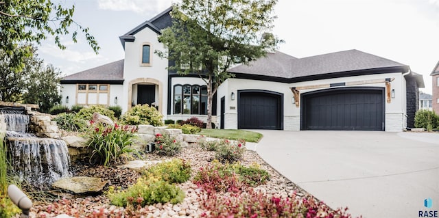 french country inspired facade with stucco siding, concrete driveway, and a garage