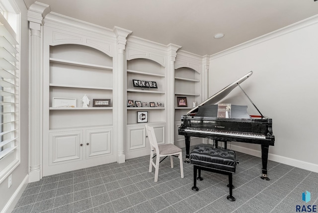 sitting room with baseboards, built in features, ornamental molding, and ornate columns