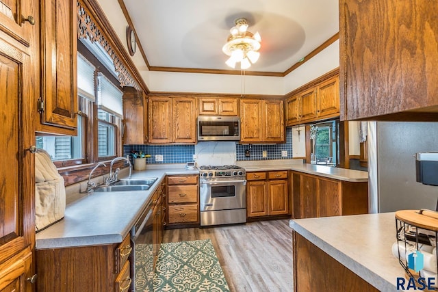 1220 NE 3rd St, Madison, SD 57042 - kitchen featuring a sink, stainless steel appliances, crown molding, and brown cabinets