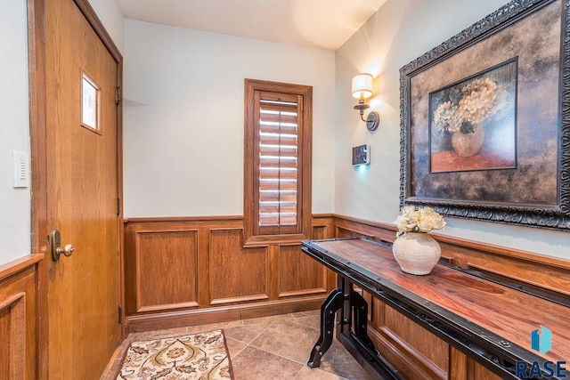 interior space featuring plenty of natural light, tile patterned floors, and wainscoting