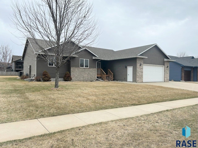 ranch-style home with driveway, a front yard, an attached garage, and brick siding