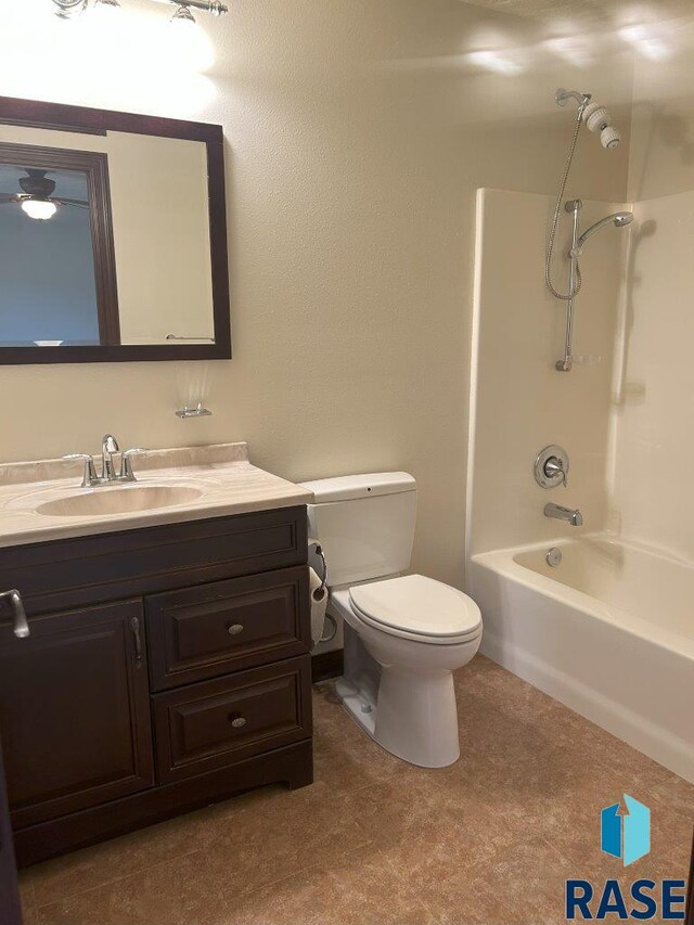 bathroom with toilet, vanity, and shower / washtub combination