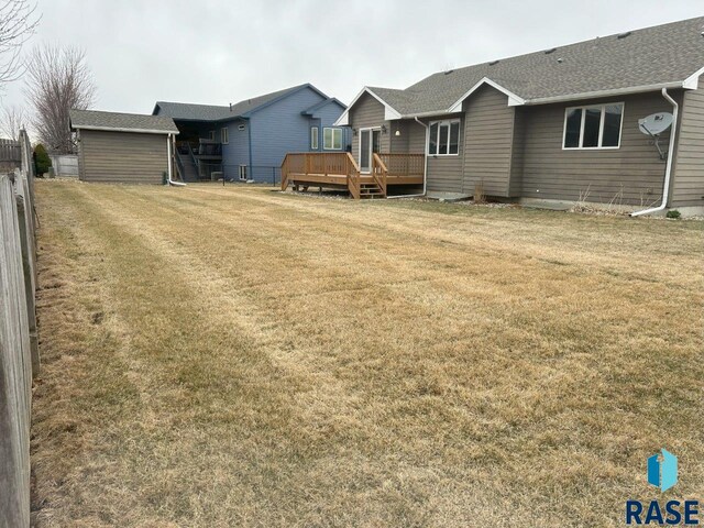 exterior space featuring fence, a lawn, and a deck