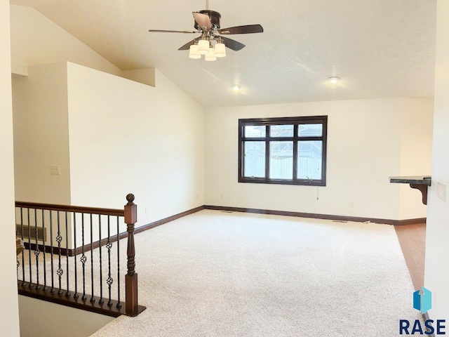 carpeted empty room with baseboards, lofted ceiling, and ceiling fan
