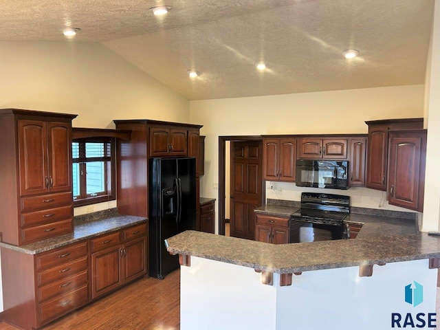 kitchen with a kitchen breakfast bar, lofted ceiling, light wood finished floors, a peninsula, and black appliances