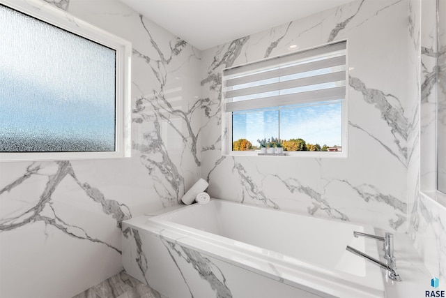 full bath with stone wall and a bath