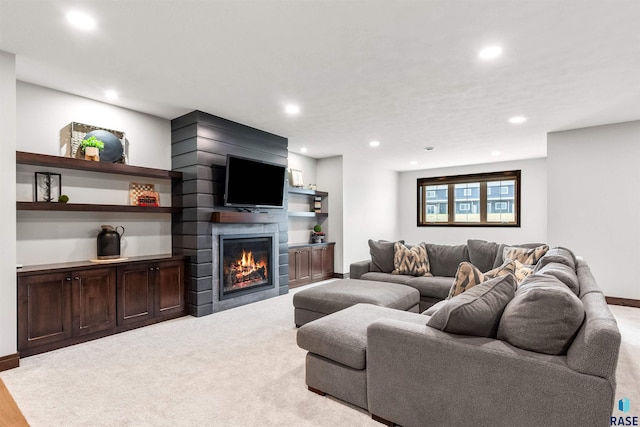 living room featuring baseboards, a fireplace, and recessed lighting
