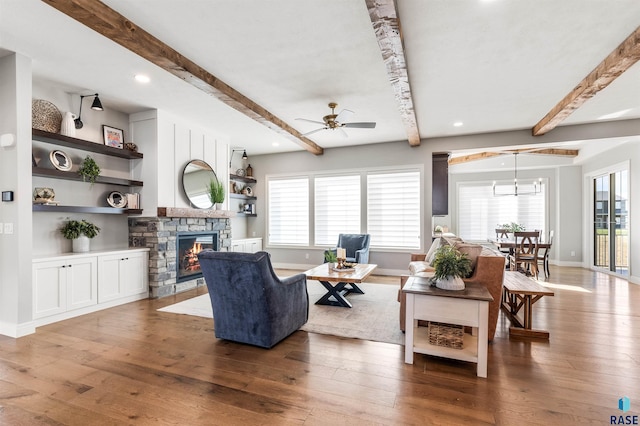 living room with baseboards, a fireplace, ceiling fan, and wood-type flooring