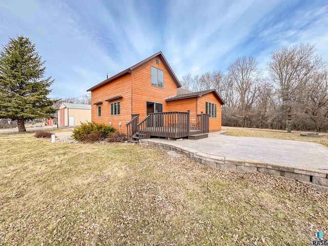back of property featuring a lawn, an outdoor structure, a deck, and a patio