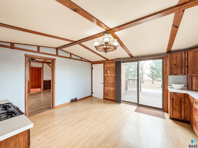 kitchen featuring light wood-type flooring, light countertops, brown cabinets, and visible vents