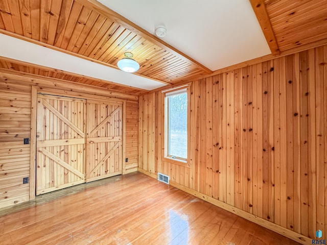 interior space featuring wood walls, visible vents, and wood-type flooring