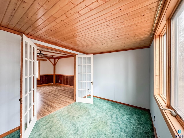 empty room with plenty of natural light, wooden ceiling, and french doors