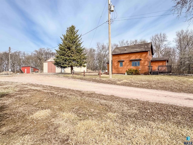 view of yard featuring an outdoor structure and driveway