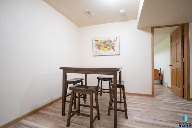 dining room with baseboards, visible vents, and light wood-style floors