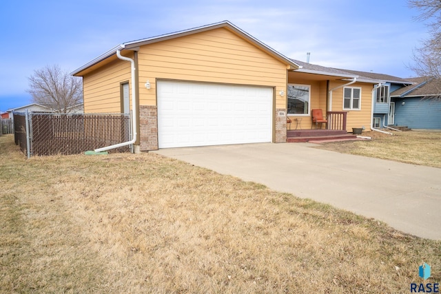 ranch-style house featuring driveway, a front yard, an attached garage, fence, and brick siding