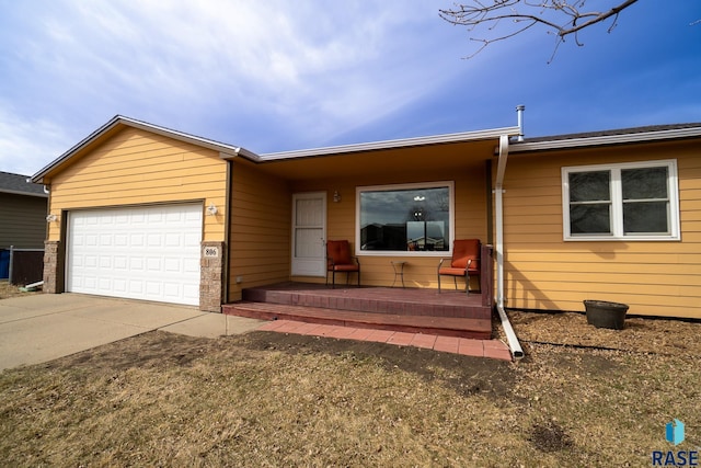 ranch-style home with a porch, concrete driveway, and an attached garage