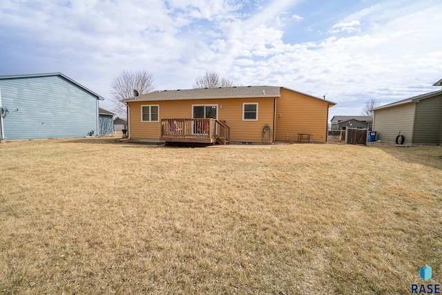 rear view of property with fence, a deck, and a yard