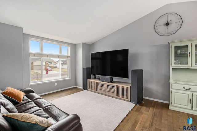 living room featuring dark wood-style floors, lofted ceiling, and baseboards