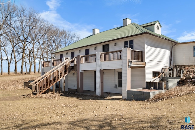 29783 Frog Creek Rd, Centerville, SD 57014 - back of house with a chimney, metal roof, a wooden deck, and stairway