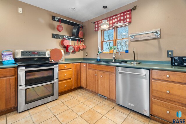 29783 Frog Creek Rd, Centerville, SD 57014 - kitchen with a sink, brown cabinetry, light tile patterned floors, and appliances with stainless steel finishes