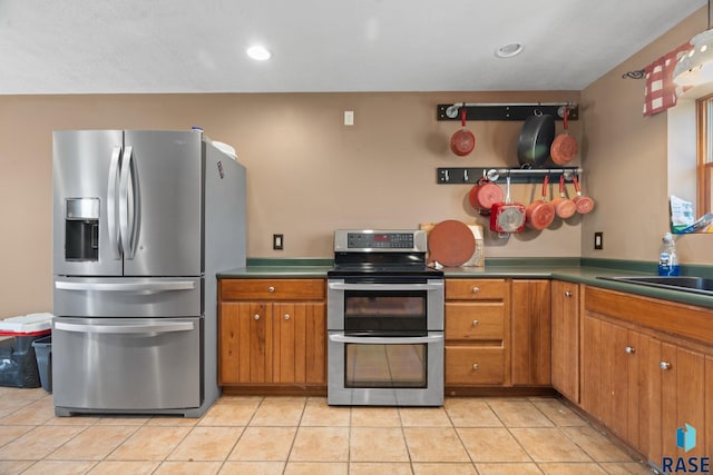 29783 Frog Creek Rd, Centerville, SD 57014 - kitchen featuring stainless steel appliances, recessed lighting, a sink, brown cabinetry, and light tile patterned floors
